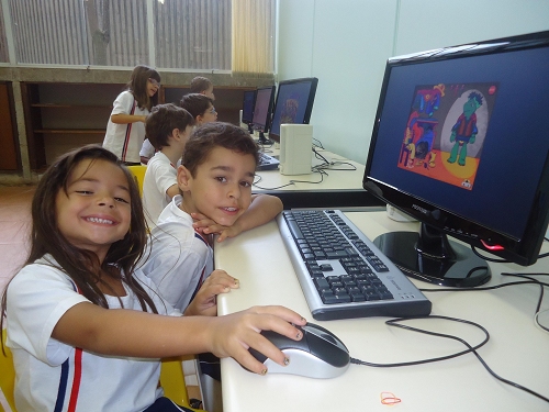 Alunas usando o computador no laboratório de informática durante as atividades permanentes