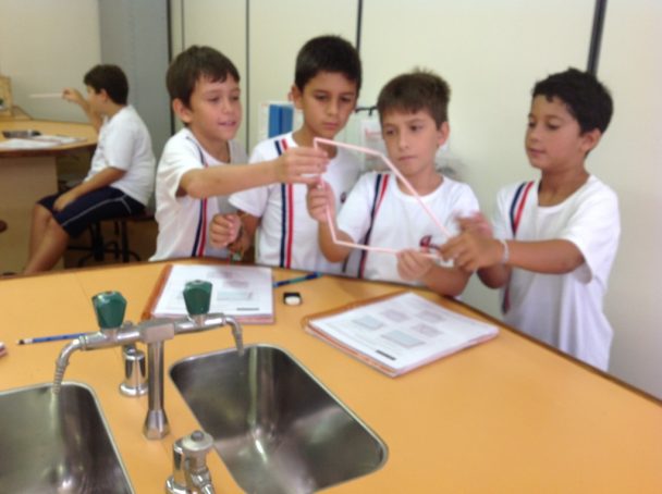Alunos em atividade prática na bancada do laboratório no projeto Geometria das Estruturas