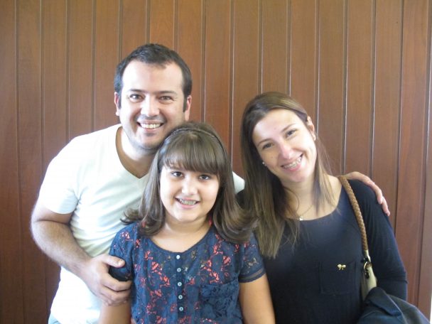 Pai, mãe e filha sorrindo juntos na comemoração do Dia dos Pais