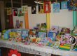 Mesa de exposição com livros e trabalhos dos alunos na mostra A Arte de Expressar