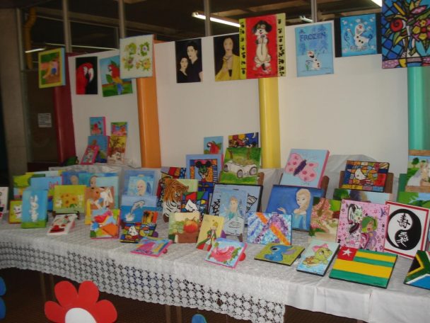 Mesa de exposição com livros e trabalhos dos alunos na mostra A Arte de Expressar