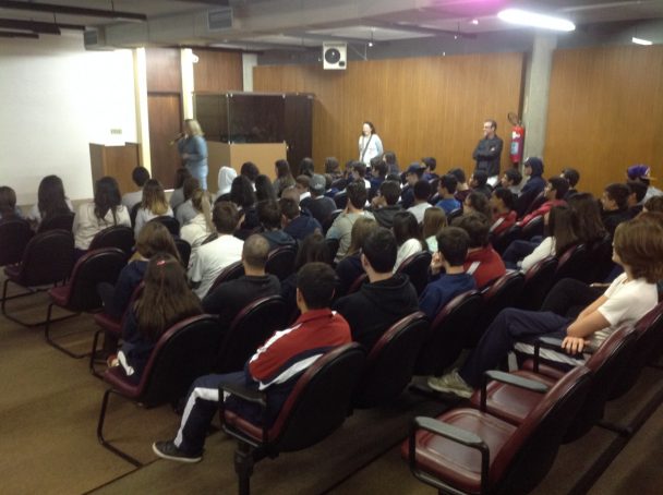 Alunos no auditório assistindo à palestra Amor Exigente