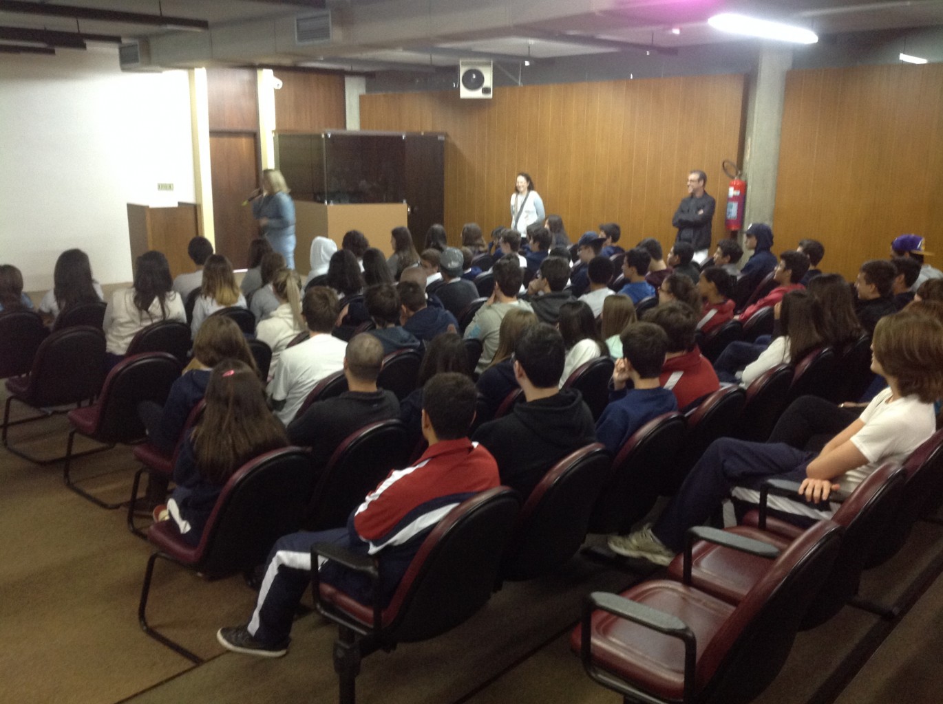 Alunos no auditório assistindo à palestra Amor Exigente