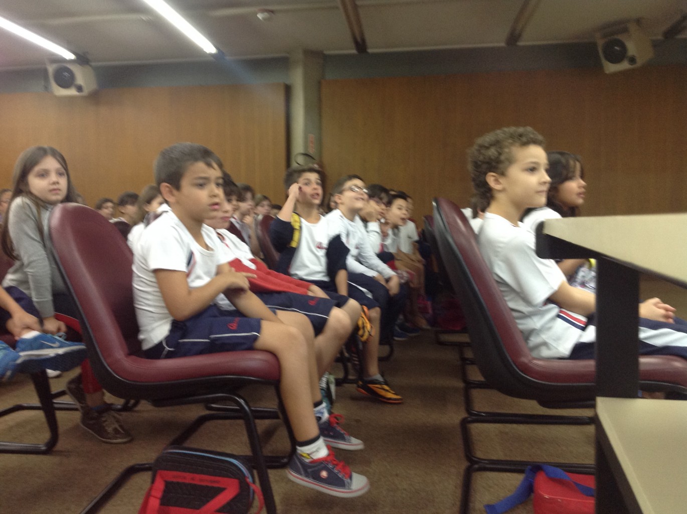 Alunos assistindo à apresentação de Boom Wackers no auditório