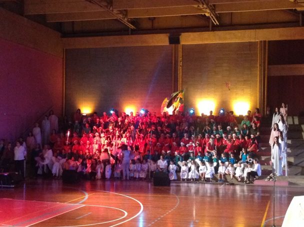 Apresentação da Cantata de Natal 2014 no ginásio, com alunos em formação sob luz cênica