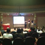 Mães e famílias na plateia do auditório durante a homenagem do Dia das Mães