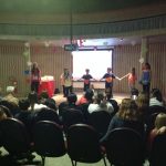 Mães e famílias na plateia do auditório durante a homenagem do Dia das Mães
