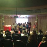 Mães e famílias na plateia do auditório durante a homenagem do Dia das Mães