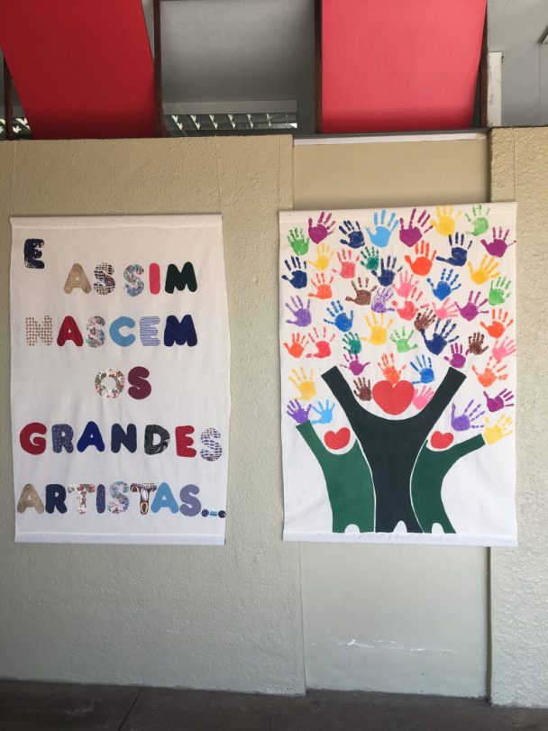 Mural com a frase E assim nascem os grandes artistas ao lado do painel de mãos pintadas, em foto de outubro