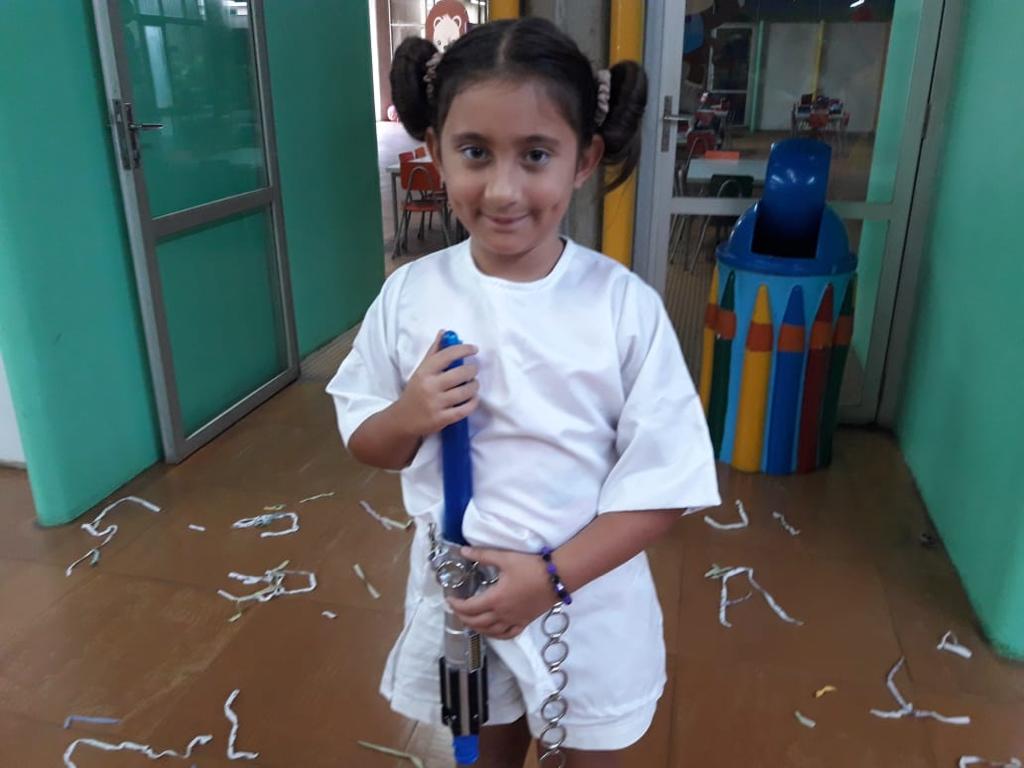 Menina fantasiada segurando um tubo de papel no Carnaval do Coração