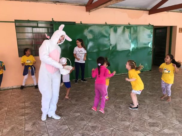 Personagem de coelho brincando com as crianças na Oficina de Páscoa da Família Coração
