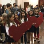 Alunos erguem corações de papel durante a Novena de Santa Rita