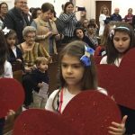 Alunos erguem corações de papel durante a Novena de Santa Rita