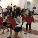 Alunos erguem corações de papel durante a Novena de Santa Rita