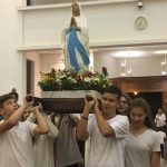 Alunos erguem balões azuis durante a Coroação de Nossa Senhora