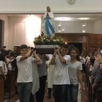 Alunos erguem balões azuis durante a Coroação de Nossa Senhora