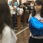 Alunos erguem balões azuis durante a Coroação de Nossa Senhora