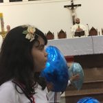 Alunos erguem balões azuis durante a Coroação de Nossa Senhora
