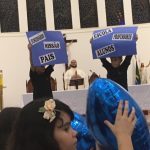 Alunos erguem balões azuis durante a Coroação de Nossa Senhora
