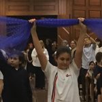 Alunos erguem balões azuis durante a Coroação de Nossa Senhora