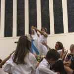 Alunos erguem balões azuis durante a Coroação de Nossa Senhora