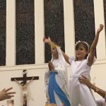 Alunos erguem balões azuis durante a Coroação de Nossa Senhora