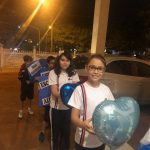 Alunos erguem balões azuis durante a Coroação de Nossa Senhora
