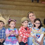 Famílias com trajes juninos posam para foto na Festa Junina 2019