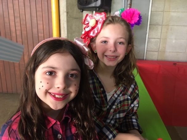 Duas meninas com laços e o rosto pintado na Festa Junina 2019