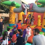 Crianças brincam nos brinquedos infláveis da colônia Super Férias