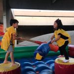 Crianças brincam nos brinquedos infláveis da colônia Super Férias