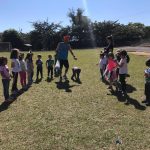 Crianças em atividade no campo durante a colônia Super Férias