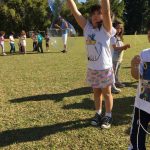 Crianças brincam com bolhas de sabão no gramado, na colônia Super Férias