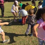 Crianças brincam com bolhas de sabão no gramado, na colônia Super Férias