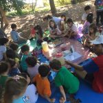 Crianças em atividade no campo durante a colônia Super Férias