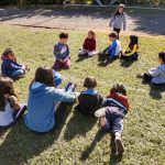 Crianças em atividade no campo durante a colônia Super Férias