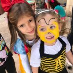 Duas meninas com o rosto pintado, uma de abelhinha, nas atividades das Super Férias