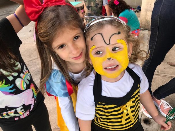 Duas meninas com o rosto pintado, uma de abelhinha, nas atividades das Super Férias