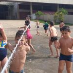 Crianças se refrescam na brincadeira com água, na colônia Super Férias