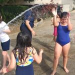 Crianças se refrescam na brincadeira com água, na colônia Super Férias