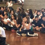 Alunos sentados no chão acompanham a apresentação da Orquestra Sinfônica de Campinas