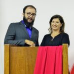 Professor e professora atrás do púlpito na Noite de Premiação