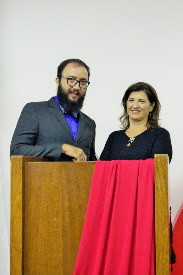 Professor e professora atrás do púlpito na Noite de Premiação