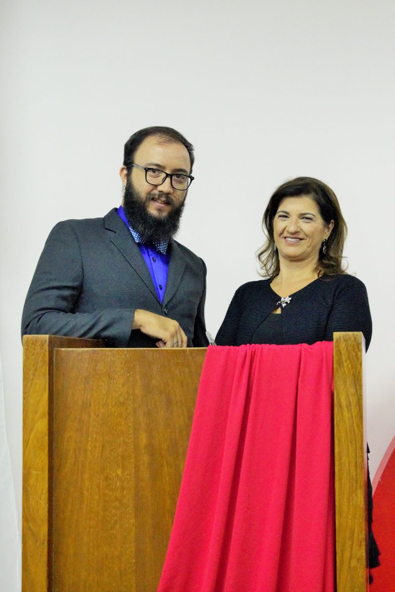 Professor e professora atrás do púlpito na Noite de Premiação