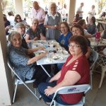 Participantes reunidos às mesas no encontro da Festa de Nossa Senhora do Calvário