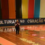 Apresentação de dança típica no ginásio durante a Semana Cultural
