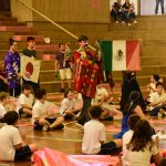Apresentação de dança típica no ginásio durante a Semana Cultural
