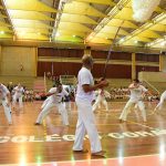 Apresentação de capoeira no ginásio durante a Semana Cultural