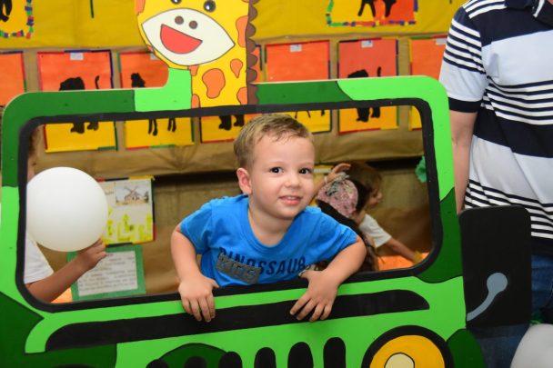 Criança pequena brincando em um carrinho de brinquedo durante a Semana Cultural