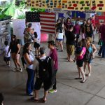 Famílias visitam os estandes da exposição da Semana Cultural